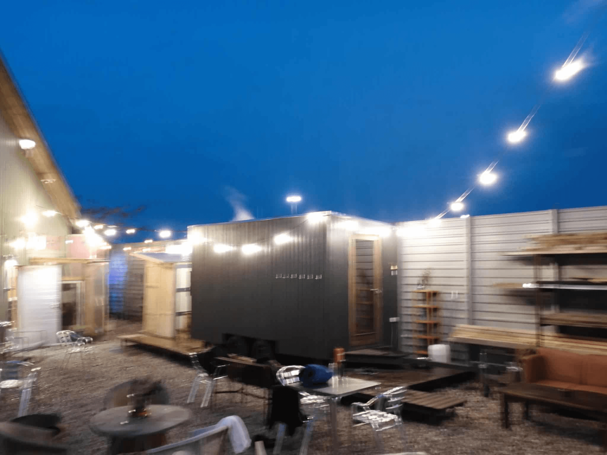 The sauna container at 'Sidste Mole' surrounded by fairy light in the summer evening.